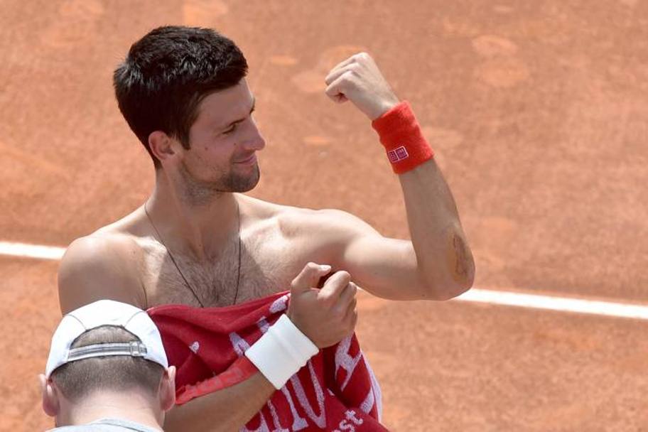 Anche un’escoriazione al gomito, per Djokovic,  un’occasione per ridere ed intrattenere i tifosi